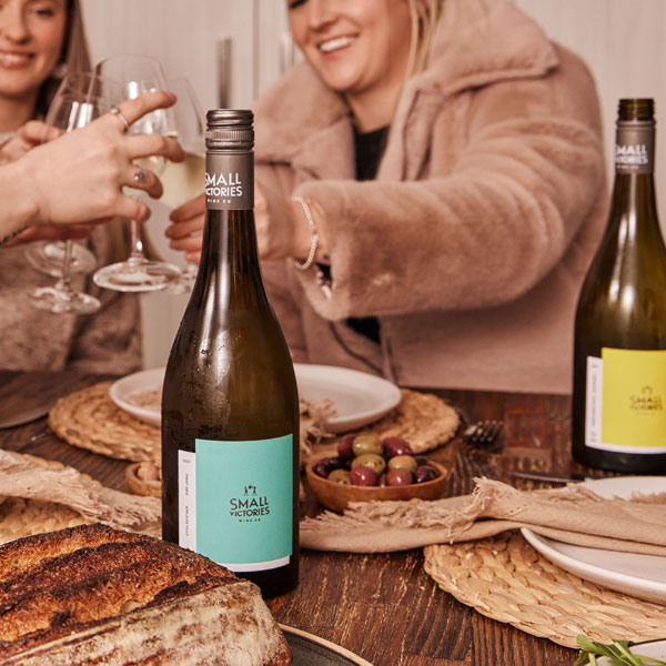 bottle of Small Victories Pinot Gris on a table at a dinner party